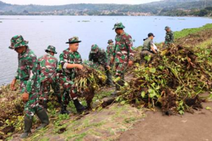 Tampah puluhan anggota TNI Kodim 0615 Kuningan sedang membersihkan eceng gondok di Waduk Darma.
